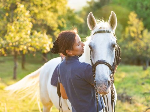 Woman standing with a white horse